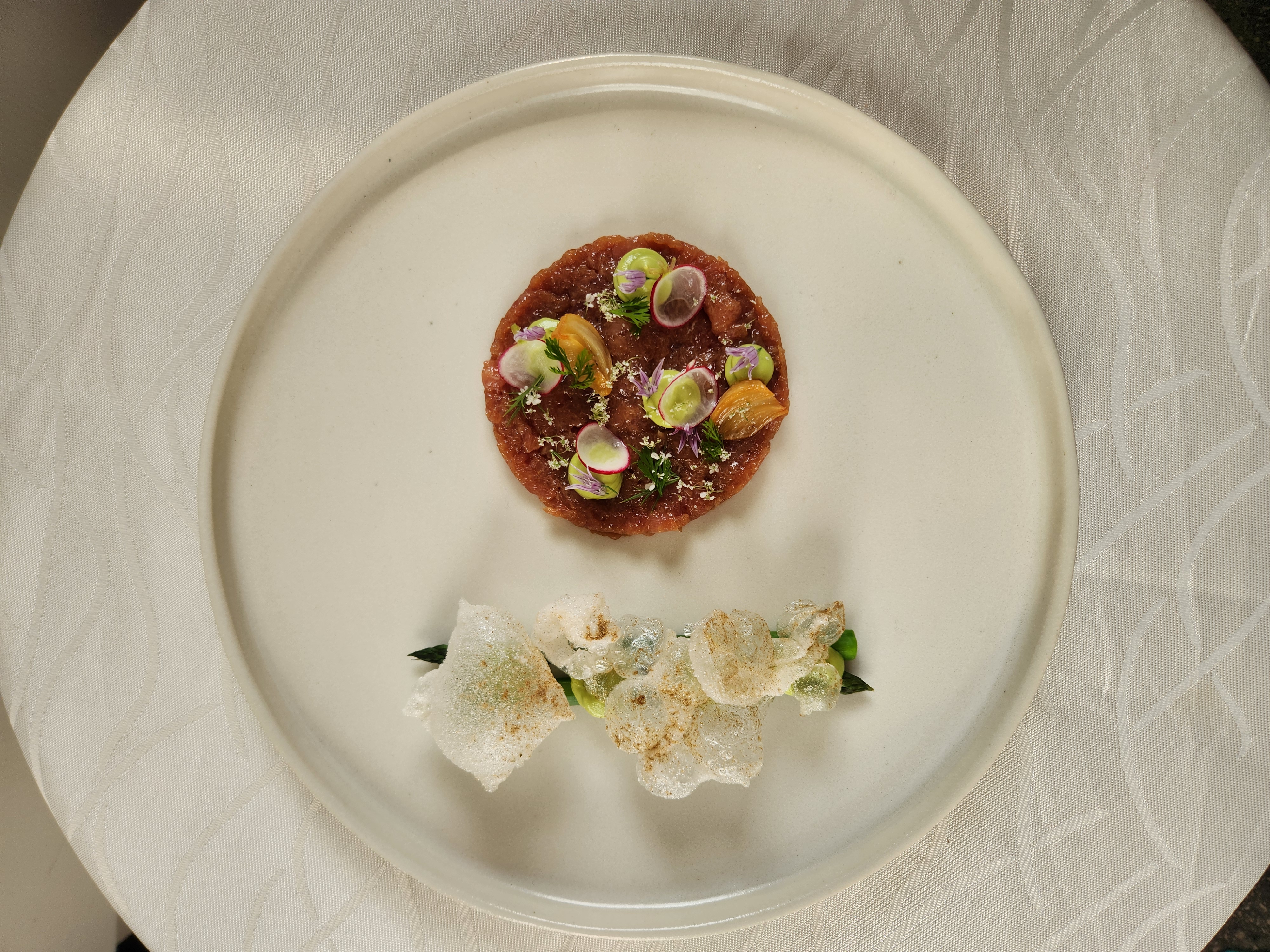 Beef tartare with edible flowers and crispy rice cracker garnish